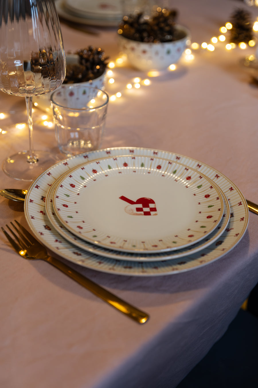 Stablede tallerkener fra Cozy Christmas med guldstreg og sløjfer