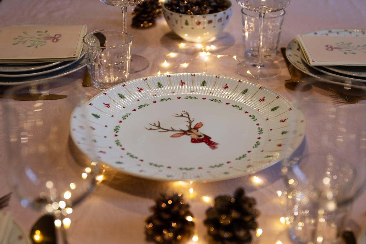 Cozy Christmas julestel dækket op med tallerken med rensdyr, kogler og lyskæde